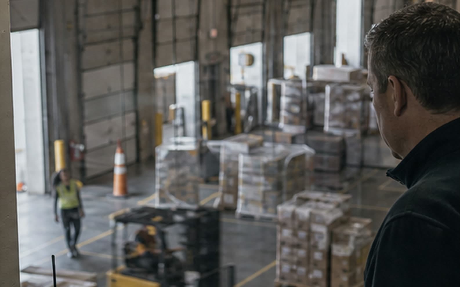 A supply-chain supervisor overlooking an active distribution center